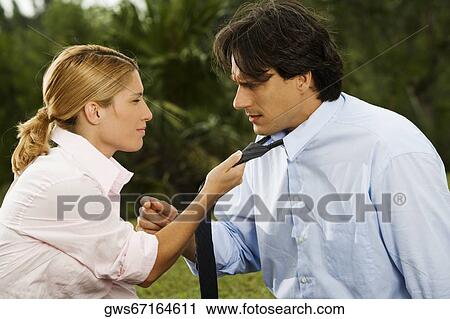 Side profile of a businesswoman holding a businessman's tie View Large Photo Image Stock Image - Side profile of a businesswoman holding a businessman's tie. Fotosearch