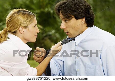Side profile of a businesswoman holding a businessman's tie View Large Photo Image Stock Image - Side profile of a businesswoman holding a businessman's tie. Fotosearch