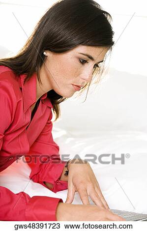 Stock Image - Side profile of a businesswoman using a laptop. Fotosearch