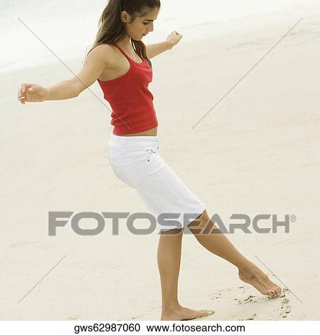Side profile of a girl drawing in the sand with her toe View Large Photo Image Stock Image - Side profile of a girl drawing in the sand with her toe. Fotosearch