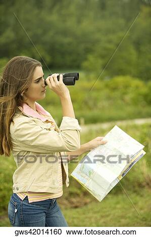 Side profile of a girl looking through a pair of binoculars View Large Photo Image Stock Image - Side profile of a girl looking through a pair of binoculars. Fotosearch