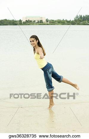 Side profile of a girl standing on one leg on the beach View Large Photo Image Stock Photography - Side profile of a girl standing on one leg on the beach. Fotosearch