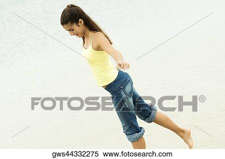 Side profile of a girl standing on one leg on the beach View Large Photo Image Stock Photography - Side profile of a girl standing on one leg on the beach. Fotosearch