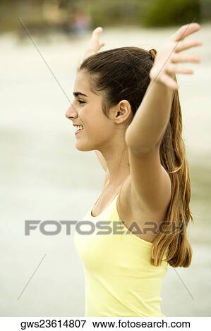 Side profile of a girl standing on the beach with her arms outstretched View Large Photo Image Stock Photo - Side profile of a girl standing on the beach with her arms outstretched. Fotosearch