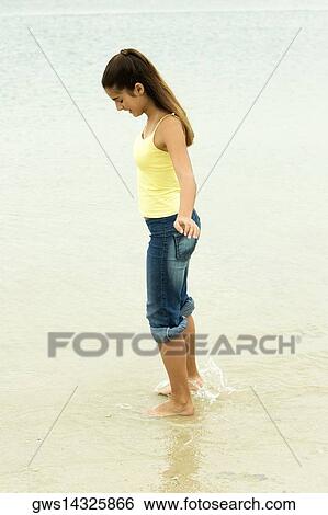 Side profile of a girl standing on the beach View Large Photo Image Stock Photograph - Side profile of a girl standing on the beach. Fotosearch