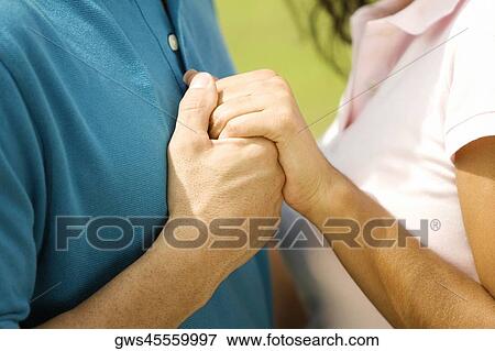 Side profile of a man and a woman holding hands View Large Photo Image Stock Photo - Side profile of a man and a woman holding hands. Fotosearch