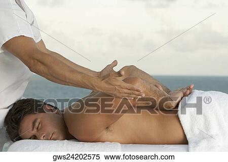 Side profile of a mature man giving a mid adult man a back massage View Large Photo Image Stock Photography - Side profile of a mature man giving a mid adult man a back massage. Fotosearch