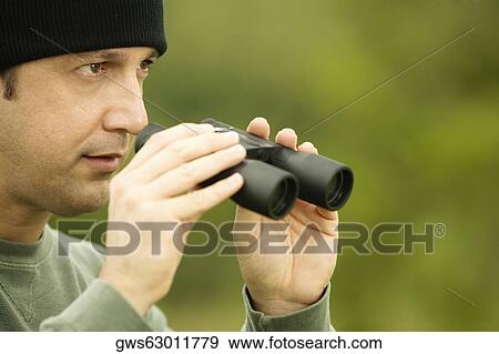 Side profile of a mature man holding a pair of binoculars View Large Photo Image Stock Photo - Side profile of a mature man holding a pair of binoculars. Fotosearch