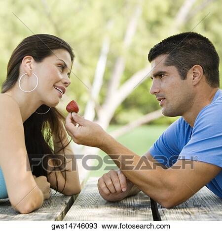 Side profile of a mid adult man feeding a young woman a strawberry View Large Photo Image Stock Image - Side profile of a mid adult man feeding a young woman a strawberry. Fotosearch