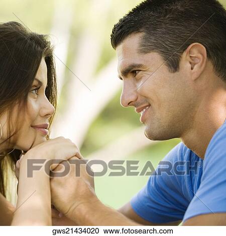 Side profile of a mid adult man looking at a young woman and smiling View Large Photo Image Stock Image - Side profile of a mid adult man looking at a young woman and smiling. Fotosearch