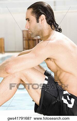 Side profile of a mid adult man sitting at the poolside View Large Photo Image Stock Photo - Side profile of a mid adult man sitting at the poolside. Fotosearch