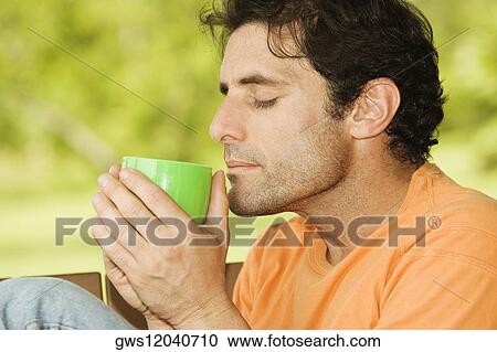 Side profile of a mid adult man drinking from a mug View Large Photo Image Stock Image - Side profile of a mid adult man drinking from a mug. Fotosearch