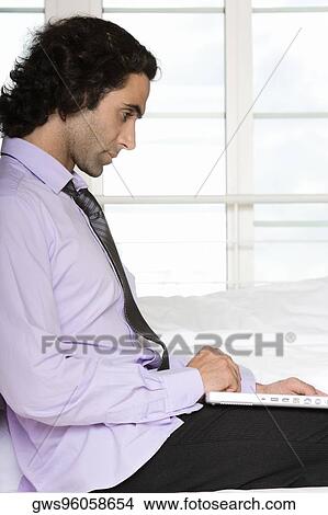Side profile of a mid adult man using a laptop View Large Photo Image Picture - Side profile of a mid adult man using a laptop. Fotosearch