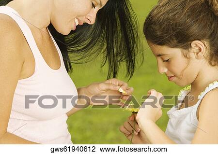 Side profile of a mother plucking a flower petal with her daughter View Large Photo Image Stock Image - Side profile of a mother plucking a flower petal with her daughter. Fotosearch