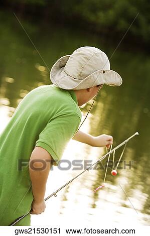 Stock Image - Side profile of a teenage boy fishing in a lake. Fotosearch