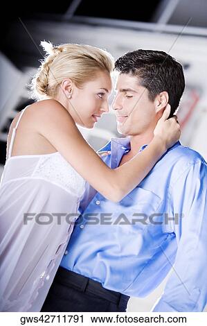 Side profile of a young woman and a mid adult man embracing each other View Large Photo Image Stock Image - Side profile of a young woman and a mid adult man embracing each other. Fotosearch