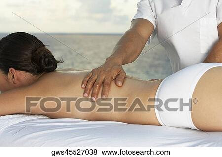 Side profile of a young woman getting a back massage View Large Photo Image Stock Photo - Side profile of a young woman getting a back massage. Fotosearch