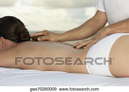 Side profile of a young woman getting a back massage View Large Photo Image Stock Photo - Side profile of a young woman getting a back massage. Fotosearch