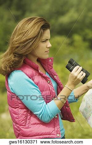Side profile of a young woman holding a map and a pair of binoculars View Large Photo Image Stock Image - Side profile of a young woman holding a map and a pair of binoculars. Fotosearch