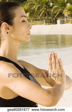 Side profile of a young woman in a prayer position View Large Photo Image Stock Photo - Side profile of a young woman in a prayer position. Fotosearch