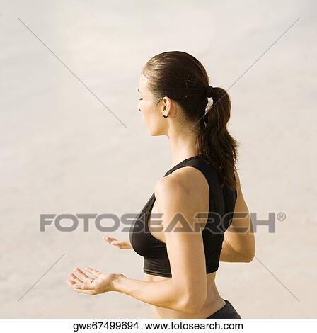 Side profile of a young woman practicing martial arts on the beach View Large Photo Image Picture - Side profile of a young woman practicing martial arts on the beach. Fotosearch