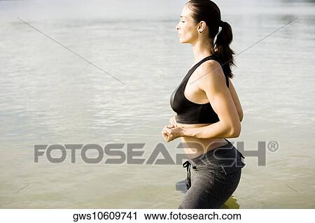 Side profile of a young woman exercising in a lake View Large Photo Image Stock Image - Side profile of a young woman exercising in a lake. Fotosearch