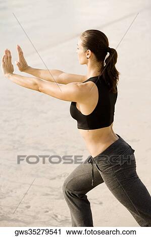 Side profile of a young woman practicing martial arts on the beach View Large Photo Image Stock Image - Side profile of a young woman practicing martial arts on the beach. Fotosearch