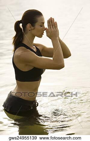 Side profile of a young woman meditating in a lake View Large Photo Image Stock Photo - Side profile of a young woman meditating in a lake. Fotosearch