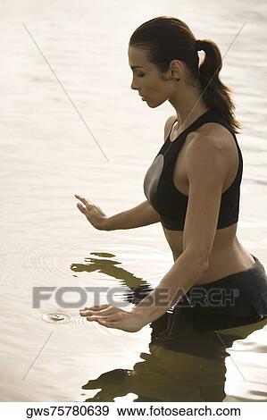 Side profile of a young woman meditating in a lake View Large Photo Image Stock Photo - Side profile of a young woman meditating in a lake. Fotosearch