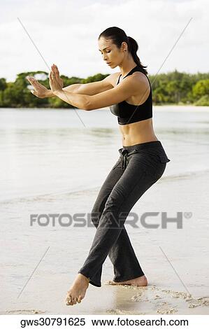 Side profile of a young woman practicing martial arts on the beach View Large Photo Image Stock Photography - Side profile of a young woman practicing martial arts on the beach. Fotosearch