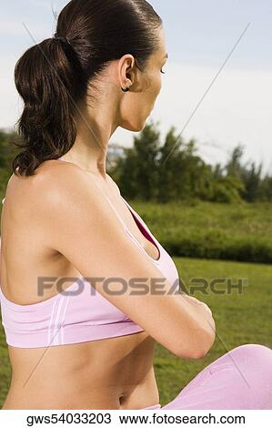 Stock Image - Side profile of a young woman stretching. Fotosearch