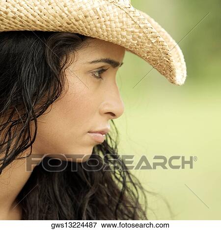 Side profile of a young woman wearing a hat View Large Photo Image Stock Photo - Side profile of a young woman wearing a hat. Fotosearch