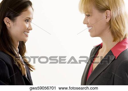 Side profile of two businesswomen smiling View Large Photo Image Stock Image - Side profile of two businesswomen smiling. Fotosearch