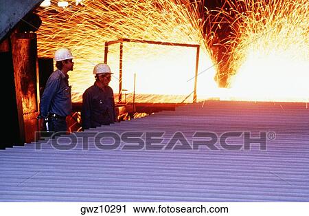Side profile of two foundry workers standing in a steel plant View Large Photo Image Stock Image - Side profile of two foundry workers standing in a steel plant. Fotosearch
