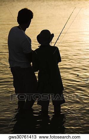 Stock Image - Silhouette of a father and his son fishing. Fotosearch