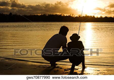 Stock Image - Silhouette of a father and his son fishing. Fotosearch