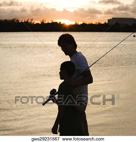 Stock Photo - Silhouette of a father and his son carrying a fishing rod. Fotosearch