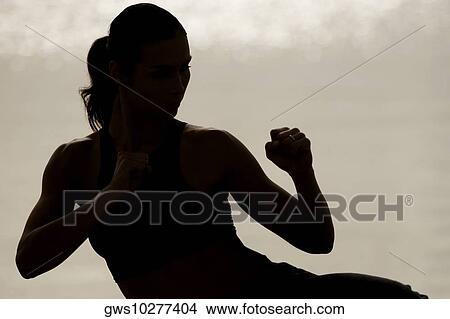Silhouette of a young woman exercising View Large Photo Image Picture - Silhouette of a young woman exercising. Fotosearch