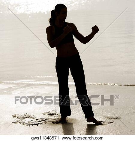 Silhouette of a young woman practicing martial arts on the beach View Large Photo Image Stock Image - Silhouette of a young woman practicing martial arts on the beach. Fotosearch