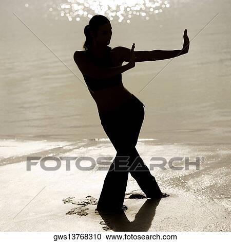 Silhouette of a young woman practicing martial arts on the beach View Large Photo Image Stock Image - Silhouette of a young woman practicing martial arts on the beach. Fotosearch