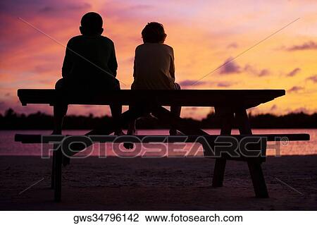 Silhouette of two boys sitting on a picnic table View Large Photo Image Stock Image - Silhouette of two boys sitting on a picnic table. Fotosearch
