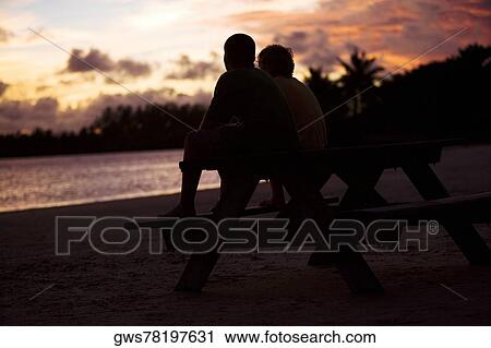 Stock Image - Silhouette of two boys sitting on a picnic table. Fotosearch