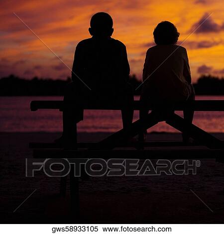 Silhouette of two boys sitting on a picnic table View Large Photo Image Stock Photography - Silhouette of two boys sitting on a picnic table. Fotosearch