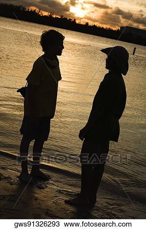 Silhouette of two boys standing on the beach View Large Photo Image Stock Image - Silhouette of two boys standing on the beach. Fotosearch