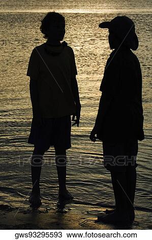 Silhouette of two boys standing on the beach View Large Photo Image Stock Image - Silhouette of two boys standing on the beach. Fotosearch