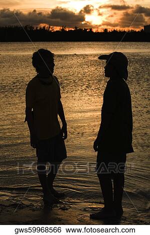 Silhouette of two boys standing on the beach View Large Photo Image Stock Photograph - Silhouette of two boys standing on the beach. Fotosearch