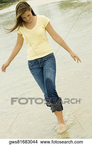 Teenage girl walking on the beach looking down View Large Photo Image Picture - Teenage girl walking on the beach looking down. Fotosearch