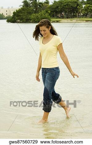 Teenage girl walking on the beach View Large Photo Image Stock Photo - Teenage girl walking on the beach. Fotosearch
