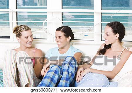 Three young women sitting together View Large Photo Image Stock Image - Three young women sitting together. Fotosearch