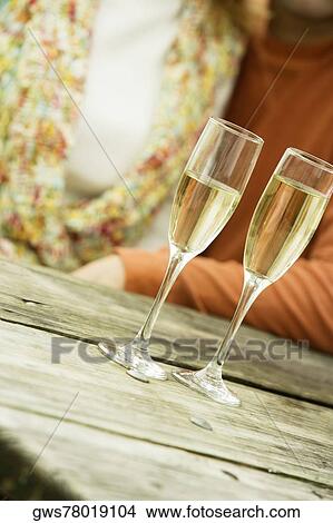 Picture - Two champagne flutes on a bench. Fotosearch